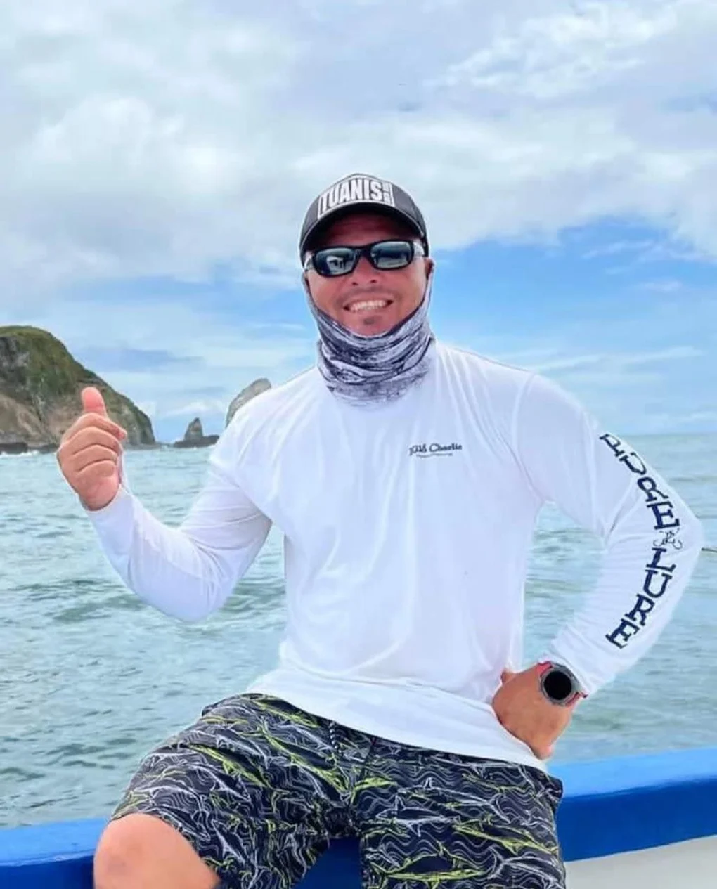 Douglas Castrillo aboard, thumbs up, the Mal País headland behind him