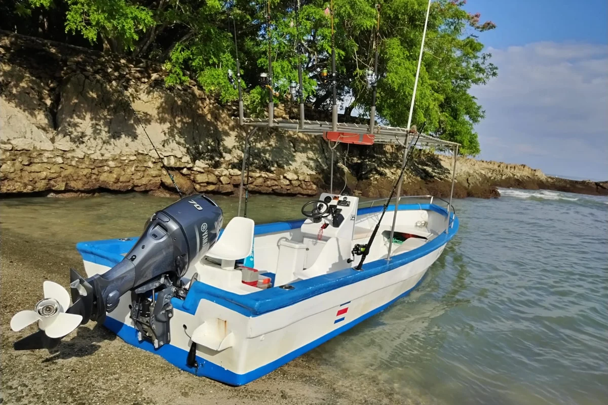The boat anchored off the rocky coastline at Mal País