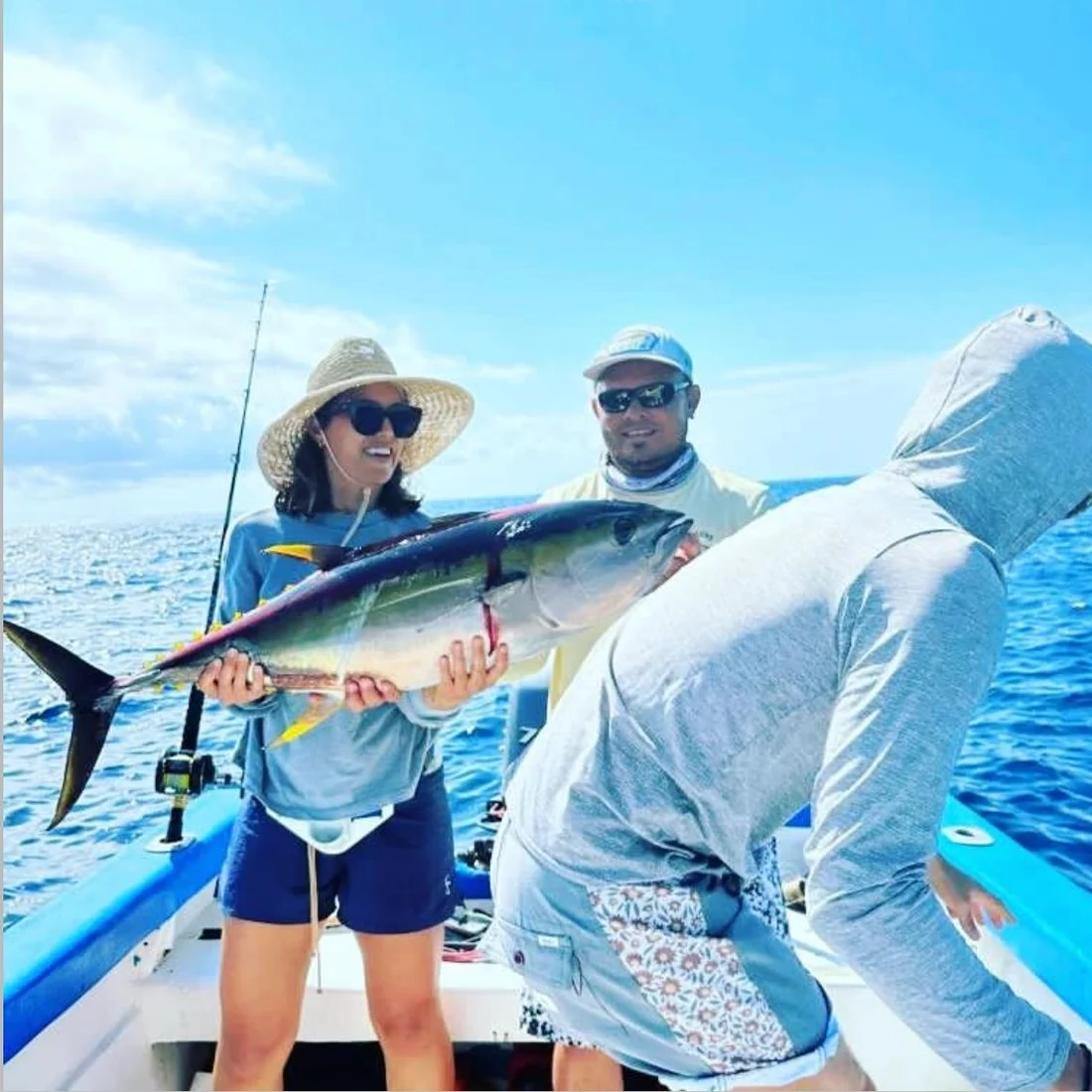 A couple aboard with a yellowfin tuna they brought up together