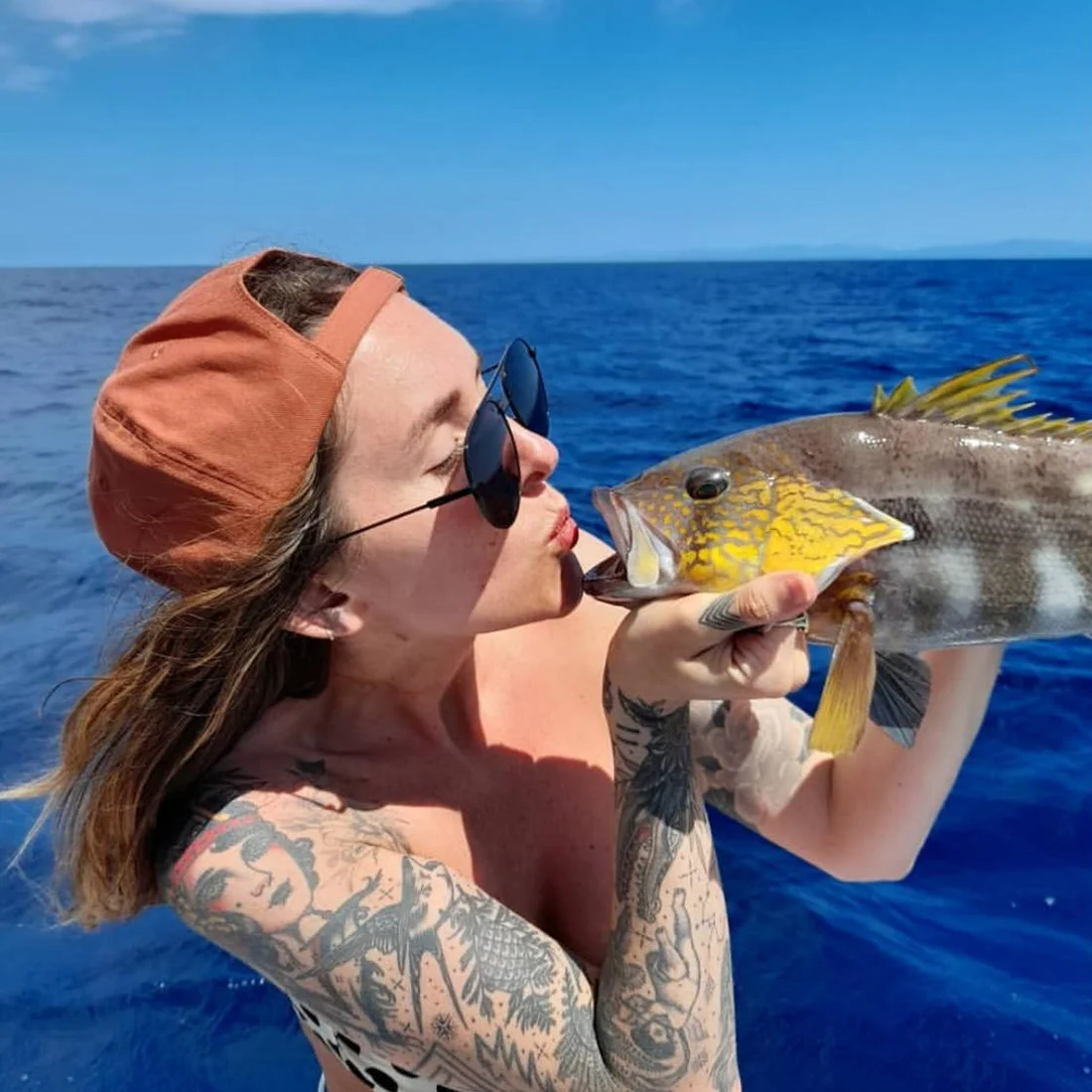 A guest kissing a snapper before it goes in the box
