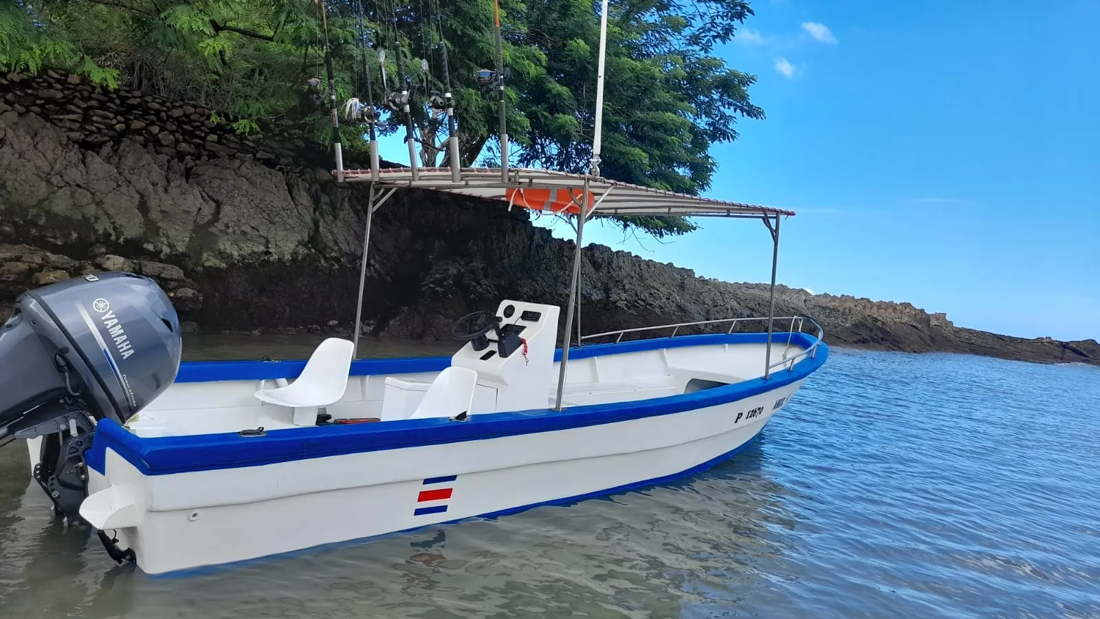 The panga anchored in front of the rocky headland at Mal País